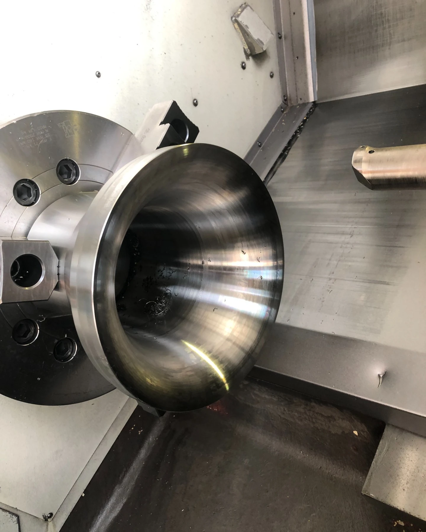 Venturi inlet cone turned on the lathe, chucked in the four jaw with the finished profile visible
